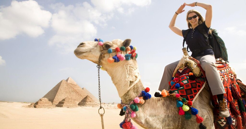 Touristin auf Kamel vor den Pyramiden – Kulturausflug in Ägypten